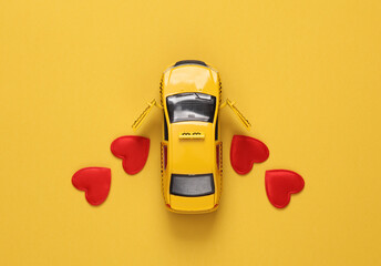 Toy taxi car with hearts on yellow background. Love, romance, valentine's day, February 14 concept