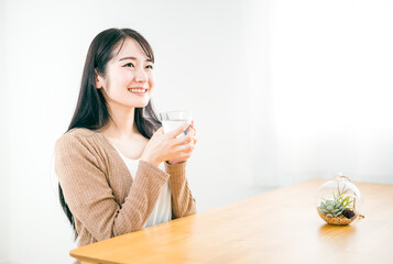 水・白湯を飲んで温活する日本人女性（笑顔）
