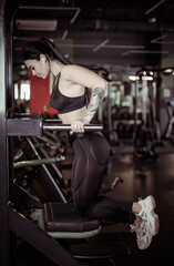 Fototapeta na wymiar Fitness woman doing push-ups on the uneven bars in the modern gym