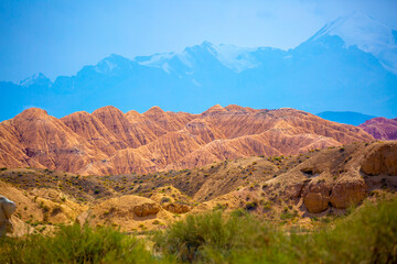 Natural unusual landscape of red rocks against the backdrop of blue mountains. The extraordinary beauty of nature is similar to the Martian landscape. Amazingly beautiful landscape.
