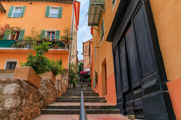 Fototapeta na wymiar Traditional old terracotta houses on a narrow street in the Old Town of Villefranche sur Mer on the French Riviera, South of France