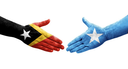 Handshake between Somalia and Timor Leste flags painted on hands, isolated transparent image.