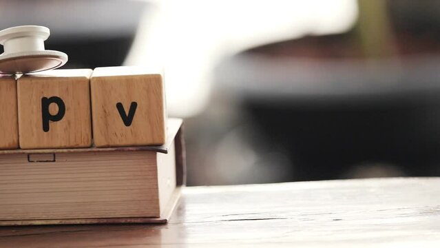 Stethoscope with  wooden box have text " HPV"  put on old book, Knowledge and detection of hpv disease Concept.