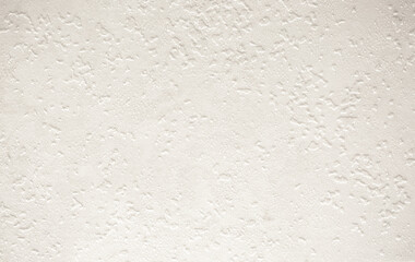 Light background of decorative plaster with abstract spots. Unusual texture of white or gray wall with beautiful patterns, creative surface background. Finishing coating for building cladding.