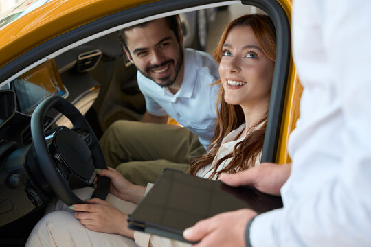 Automotive dealership clients communicating with auto sales representative