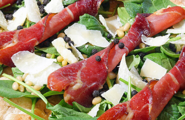 pizza with Grana Cheese Rucola cheese flakes and sliced bresaola salami