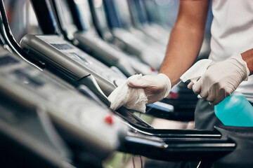 Cleaning, treadmill and sanitizing equipment in gym for bacteria, germs or protection from covid....