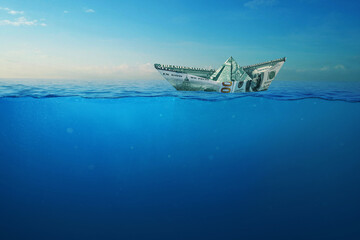 Creative dollar paper ship sailing on the high seas with a view underwater. Finance and Insurance, Concept. Crisis and Depth. Business and the sea.