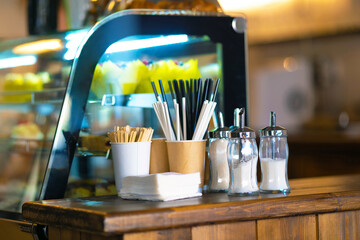 Glass sugar bowls in selective focus on a table in a cafe.