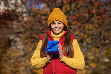 teen kid smile with present box in autumn