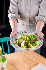 Fresh salad of tomatoes, radishes, apples, cucumbers, lettuce, arugula with sauce.