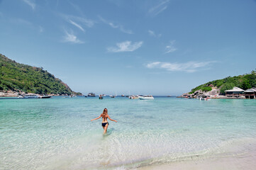 Vacation on the seashore. Young woman bathing on the beautiful tropical beach.
