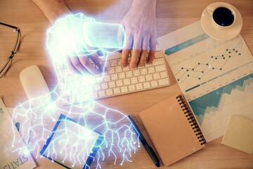 Double exposure of man's hands typing over computer keyboard and virtual reality hologram drawing. Top view. Technology concept. Future.