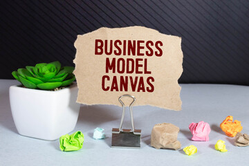 Business Model Canvas. Paper ship and sheet on a gray background.