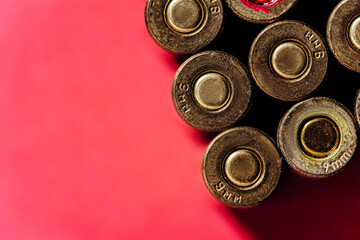 Small caliber cartridges on a red background.