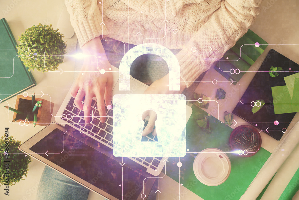 Poster double exposure of woman hands working on computer and lock hologram drawing. top view. security con