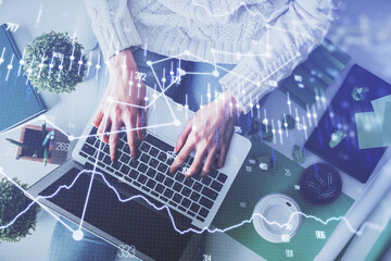 Double exposure of woman hands working on computer and forex chart hologram drawing. Top View. Financial analysis concept.