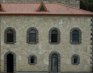Windows and doors in the modern stone wall.  Elements of architectural decorations of buildings, doorways and arches. Stone Faced Single Family House. Home Suburban.