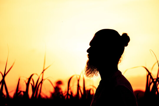 Silhouette of a man with beard and long tied hair.