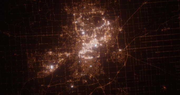 Fort Wayne (Indiana, USA) aerial view at night. View on modern city from space. Camera is zooming in, rotating counterclockwise