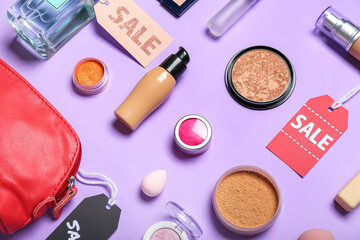 Red bag with cosmetics, accessories and sale tags on lilac background