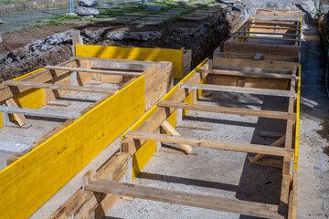 Works in the street. Trench with yellow timbers and metal bars to create the foundation of a house structure. Tenerife, Canary Islands, Spain 