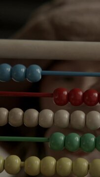 Young asian girl using an old wooden abacus and calculator doing mathematics
