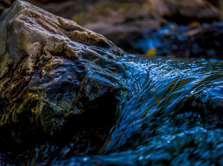 Smooth cascade created by a small stream of freshwater. Beautiful details of nature.