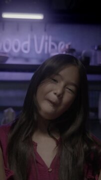 young asian girl eating donuts,. pink and yellow