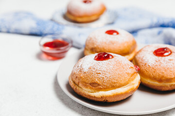 Sufganiyot jelly doughnuts cooked in oil on white table background. Traditional Jewish festive food...