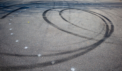 skid marks on a road surface. Circular tire marks left by drivers doing doughnuts