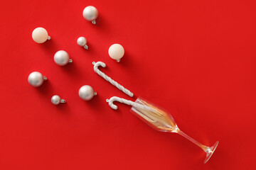 Composition with glass and Christmas decorations on red background © Pixel-Shot