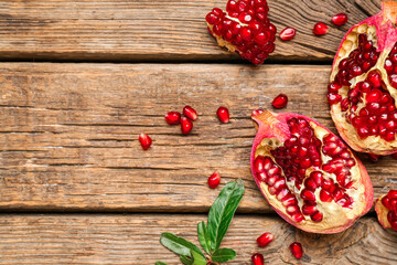 Fototapeta na wymiar Fresh ripe pomegranates on wooden background