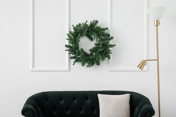 Christmas wreath hanging on light wall in living room