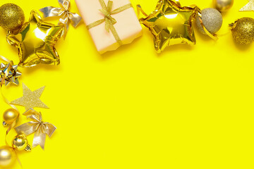 Composition with Christmas gift, decorations and balloons on yellow background
