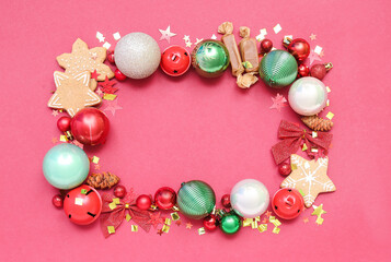 Frame made of Christmas decorations, sweets and confetti on red background
