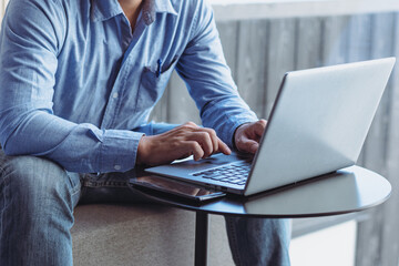 man sitting on laptop keyboard