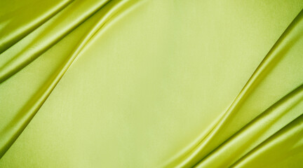 Yellow green silk satin. Lime color shiny silky smooth fabric. Soft wavy folds. Elegant background...