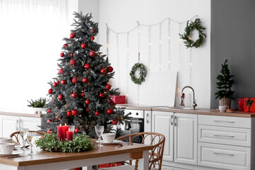 Interior of kitchen with Christmas trees and dining table