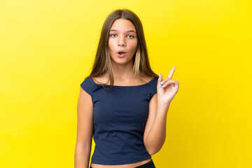 Little caucasian girl isolated on yellow background intending to realizes the solution while lifting a finger up