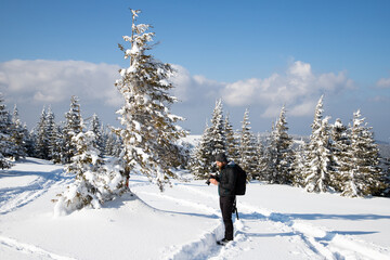 Fototapeta na wymiar man and dog trekking in big snow in mountains in winter