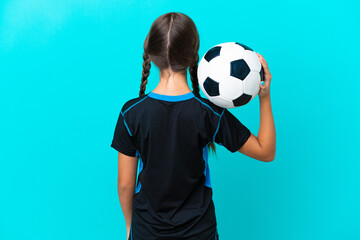 Little caucasian girl isolated on blue background with soccer ball