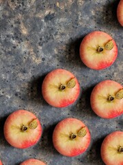 Apple pattern on black concrete background. Red apple with green leaf on black table.