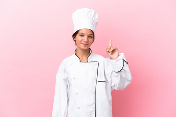 Little caucasian chef girl isolated on pink background pointing with the index finger a great idea