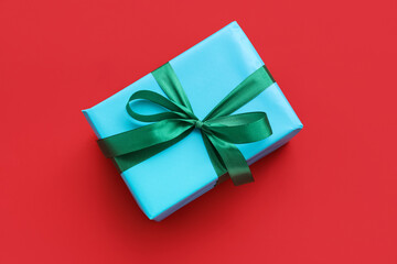 Beautiful Christmas gift tied with ribbon on red background