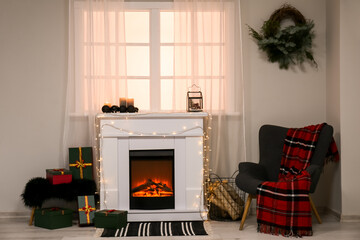 Interior of living room with fireplace, glowing lights and armchair