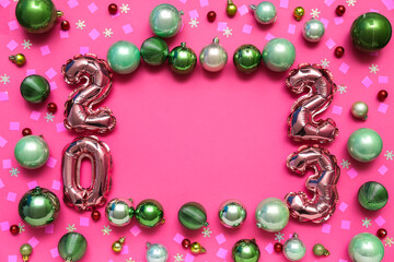 Frame made of foil balloons, Christmas balls and confetti on pink background