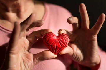 Woman’s hands holding red 3d printed heart. Ideal for diverse concept : love and health, gratitude and charity either technology