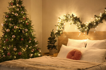 Interior of bedroom with glowing Christmas trees and fir branches