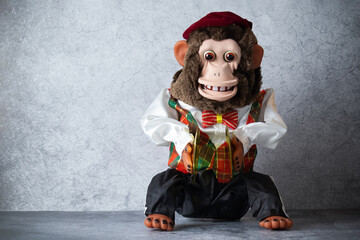 Retro toy monkey with cymbals, jolly chimp, on gray surface 